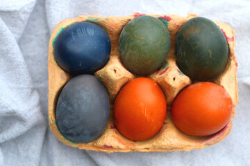 Egg carton with six painted eggs on the table. Flat lay.