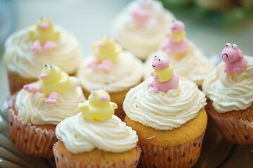 Holiday cupcakes with cream and marshmallow figurines are on the festive table. Close-up