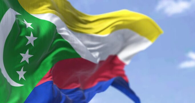 Detail of the national flag of Comoros waving in the wind on a clear day. Comoros is an archipelagic country in the Indian Ocean. Patriotism. Selective focus.