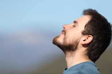 Close up portrait of a man breathing fresh air outdoors
