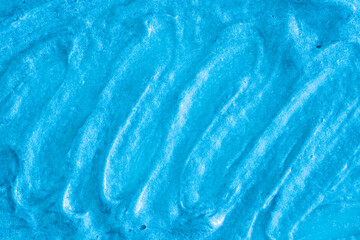 Blue cream texture. The surface of berry yogurt and a smoothie of whipped cream. Background texture of masks and scrubs for face and body. Pearlescent silver surface of blue foam.