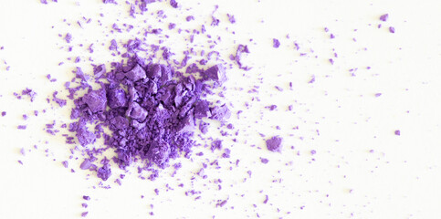 Colored powder on a white background. Purple eyeshadows are scattered and smeared, makeup. Holi Colorful festival of colored paints powders and dust. A holiday of bright colors to entertain people.