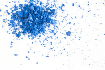 Colored powder on a white background. Blue eyeshadows are scattered and smeared, makeup. Holi Colorful festival of colored paints powders and dust. A holiday of bright colors to entertain people.