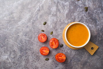 vegetarian carrot soup , on a gray concrete background, top view, close-up