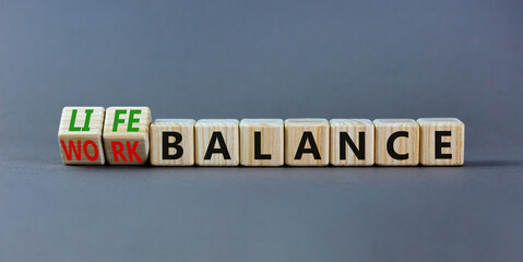 Obraz premium Work life balance symbol. Turned wooden cubes and changed concept words Work balance to Life balance. Beautiful grey table grey background. Business work life balance concept. Copy space.