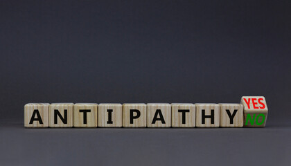 Antipathy yes or no symbol. Psychologist turns a wooden cube and change words Antipathy no to Antipathy yes. Beautiful grey background. Business and antipathy yes or no concept, copy space.