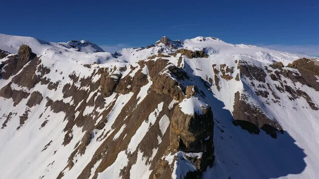 Aerial drone footage of the alps mountain above the Anzere ski resort in the alps in canton Valais in Switzerland on a sunny winter day. Shot with a tilt down motion