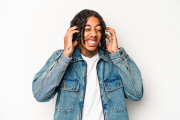 Young African American man isolated on white background covering ears with hands.