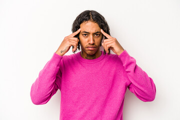 Fototapeta premium Young African American man isolated on white background focused on a task, keeping forefingers pointing head.