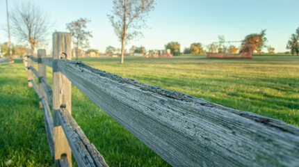 Sunrise shining on the wooden fence gurading the grass land