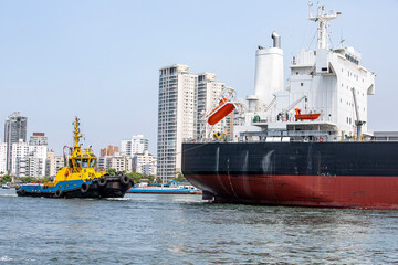 Fototapeta premium tugboat maneuvers a ship at port fo Santos, Brazil
