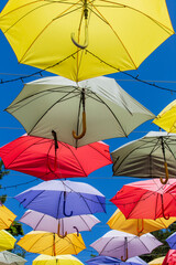 Fototapeta na wymiar Colored umbrellas hung above street