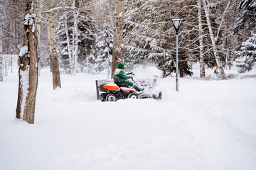 A snow blower drives down the street clearing snow. Snow removal machine.