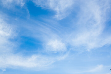 Huge clouds in blue sky lit by the sun, windy day. Beautiful sky background.