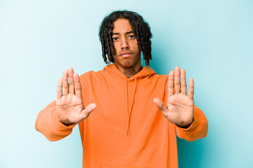Young African American man isolated on blue background standing with outstretched hand showing stop...