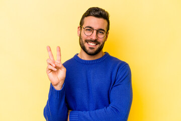 Fototapeta premium Young caucasian man isolated on yellow background showing number two with fingers.