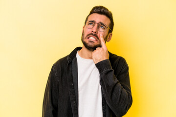 Young caucasian man isolated on yellow background crying, unhappy with something, agony and confusion concept.