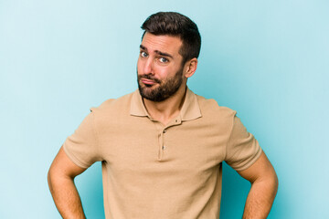 Obraz premium Young caucasian man isolated on blue background confused, feels doubtful and unsure.