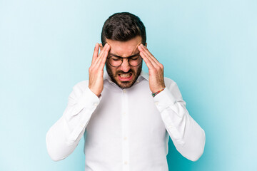 Young caucasian man isolated on blue background touching temples and having headache.