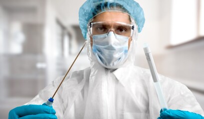 Medical healthcare professional holding COVID-19 swab collection kit,