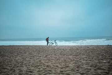 Fototapeta na wymiar persona con bicicleta en la playa