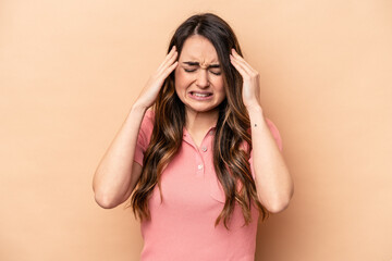 Young caucasian woman isolated on beige background having a head ache, touching front of the face.