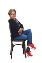 Fototapeta premium side view of a full portrait of happy senior woman sitting on white background