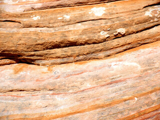 Orange and tan, layered, mottled patterns in desert sandstone, in the Bears Ears wilderness area of Southern 