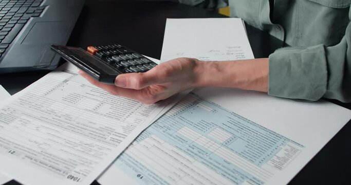 Woman calculate and filling US tax form 1040 in tax time. Individual Income Tax Return Form 1040