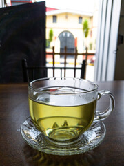Transparent cup of hot tea on a wooden table on a background of nature