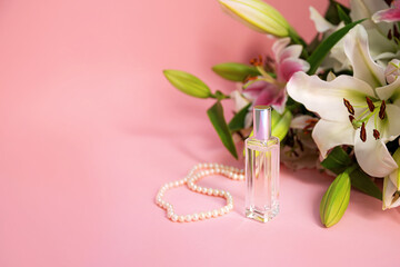 Obraz premium Women stuff: pearl neck chain, perfume and lilies on light pink background, women's day concept, space for text