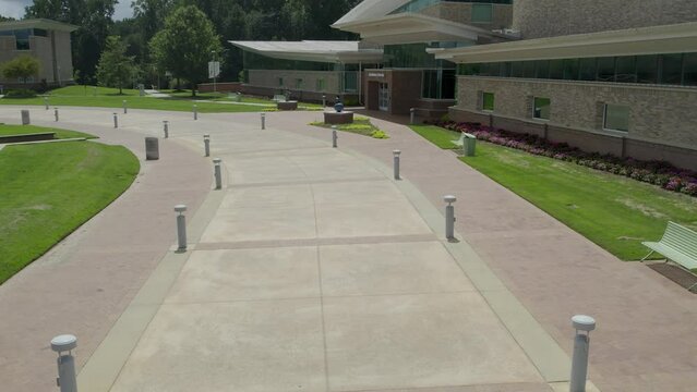 Drone aerial fly over sidewalk with light post lining each side.