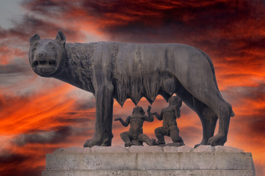 she wolf roman empire symbol breast feeding newborn romolus and remus statue on red sunset background