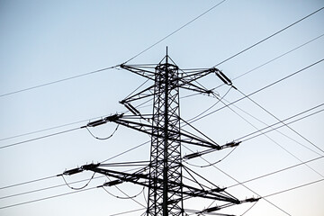 Strommast vor blauem Himmel mit sehr vielen Leitungen