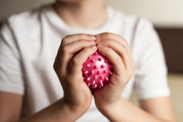 self-massage of hands with a ball with spikes