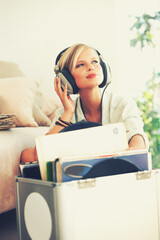 Find your freedom in the music. A beautiful young woman listening to music while relaxing at home.