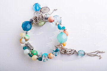 jewerly bracelet with semiprecious stones around  white background. top view