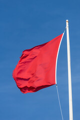 Close up of a red flag blowing in the wind