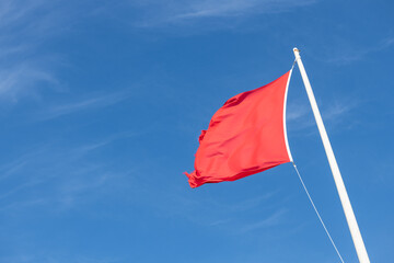 Close up of a red flag blowing in the wind