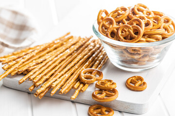Mini pretzels and salted sticks. Crusty salted snack on cutting board.