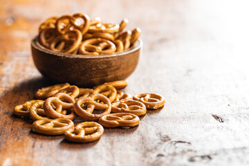 Mini pretzels. Crusty salted snack on wooden table.