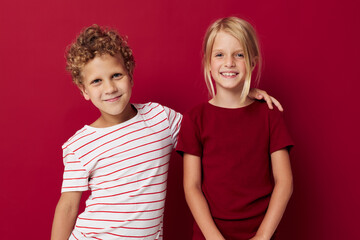 Cute preschool kids smiling and posing in casual clothes against red background