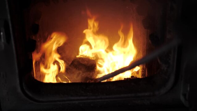 A worker kindles coal. Closes the furnace.