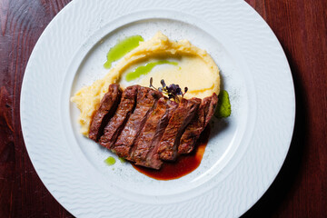 Grilled meat with sauce and mashed potatoes.