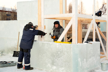 Workers on the installation of the frame of a wooden slide