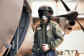 Ready for flight. A pilot standing in full gear next to his plane. - obrazy, fototapety, plakaty