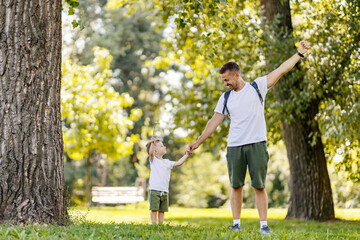 A little boy and father conquer the goal in nature on earth's day.