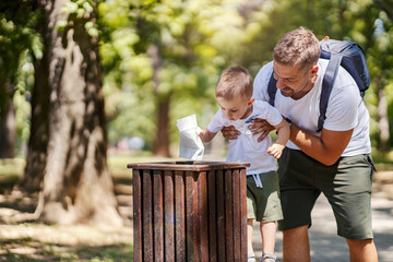 Father teaching son to have habit to recycle paper.