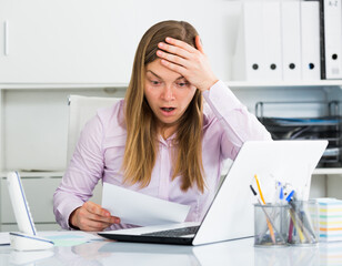 Young female worker having problem in project in office
