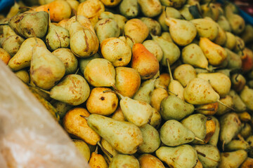Pequeñas peras apiladas en mercado o feria local